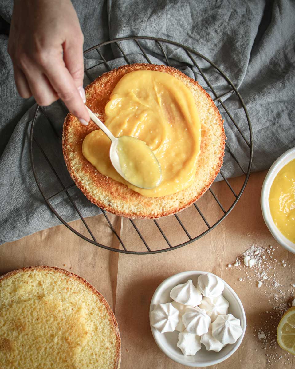 spreading lemon butter on a cake