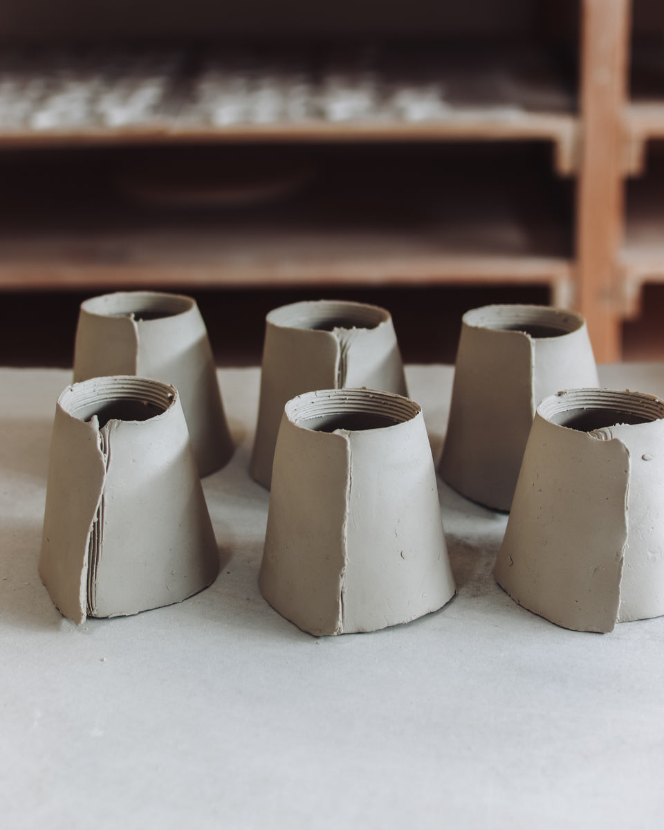Row of clay cups being made
