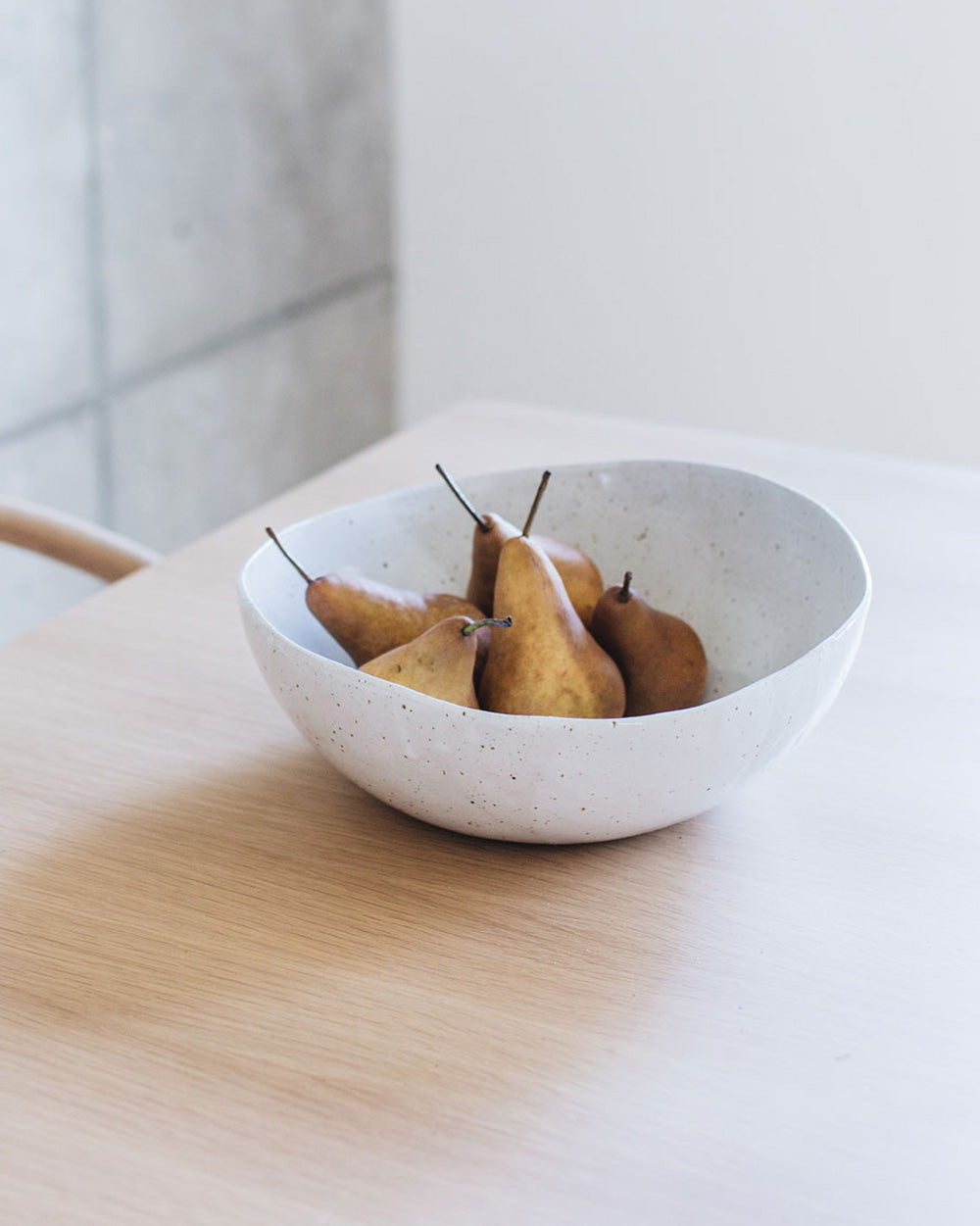 wabi sabi bowl filled with pears on a table