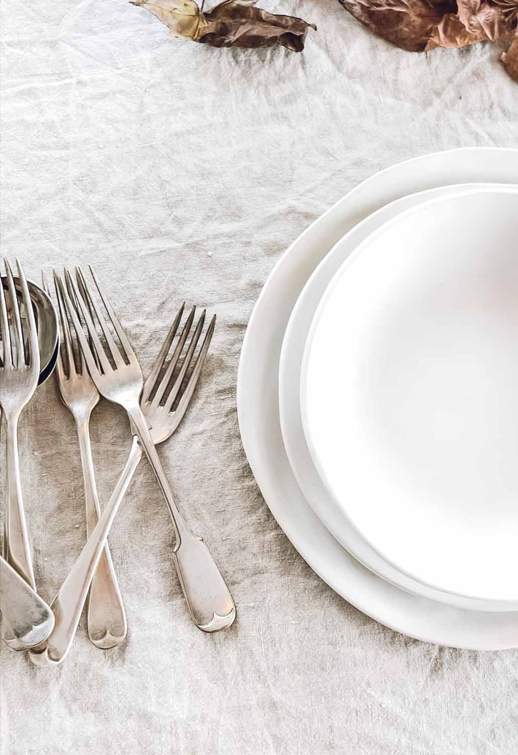 Table style with handmade ceramics, autumn leaves and vintage cutlery