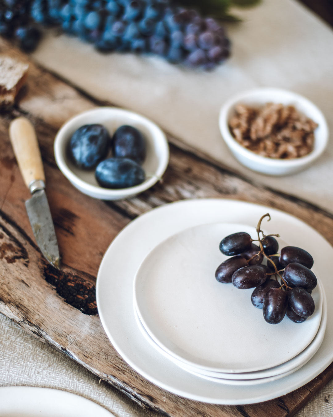 Grapes and plums on a handmade ceramic plates