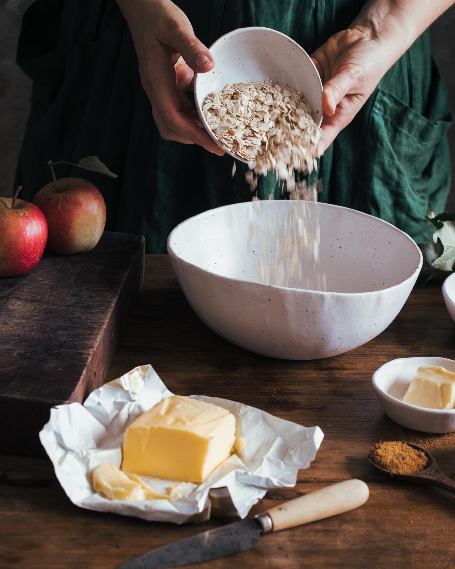 Pouring oats into a handmade ceramic mixing bowl