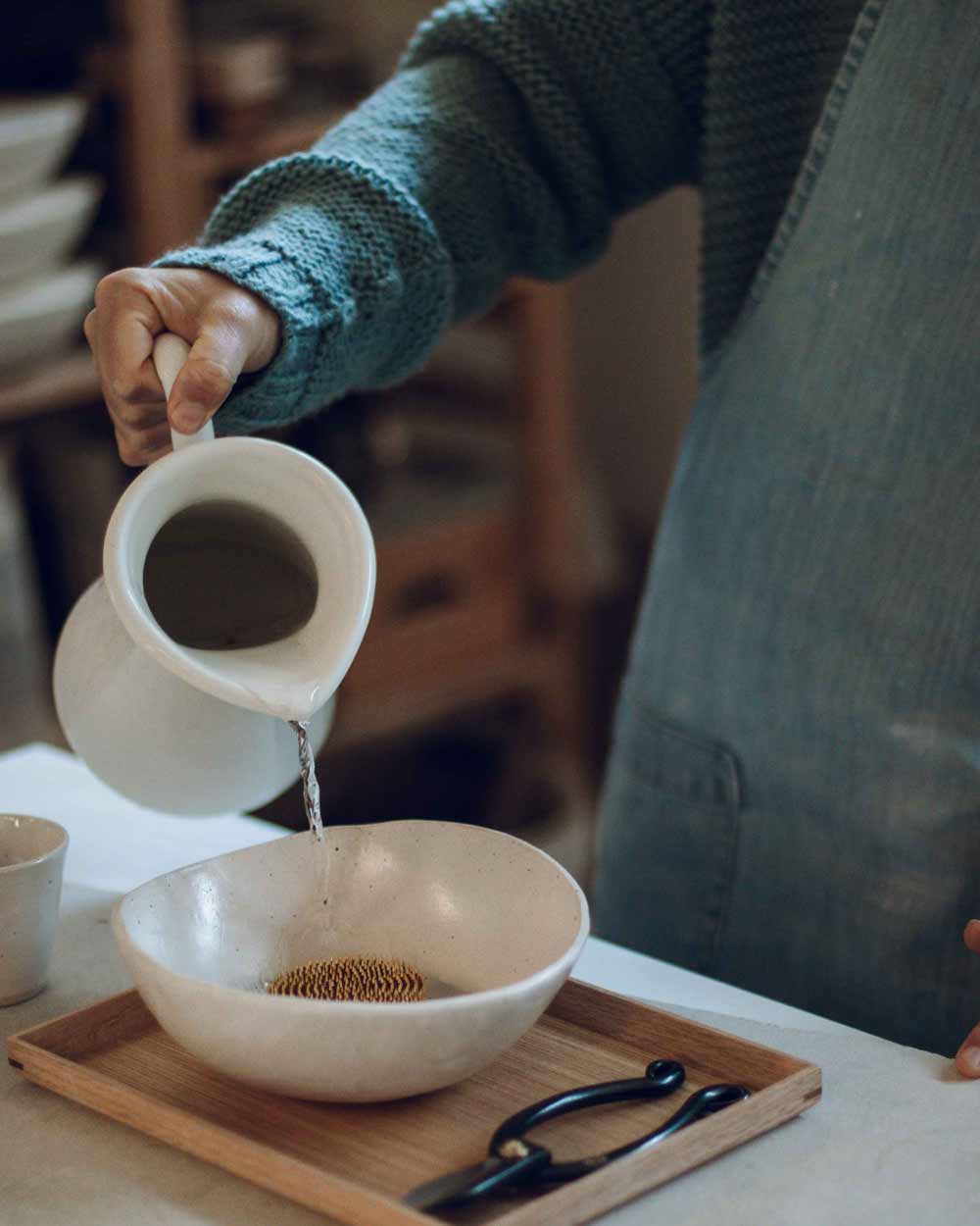 Pouring water into a bowl for an ikebana arrangement