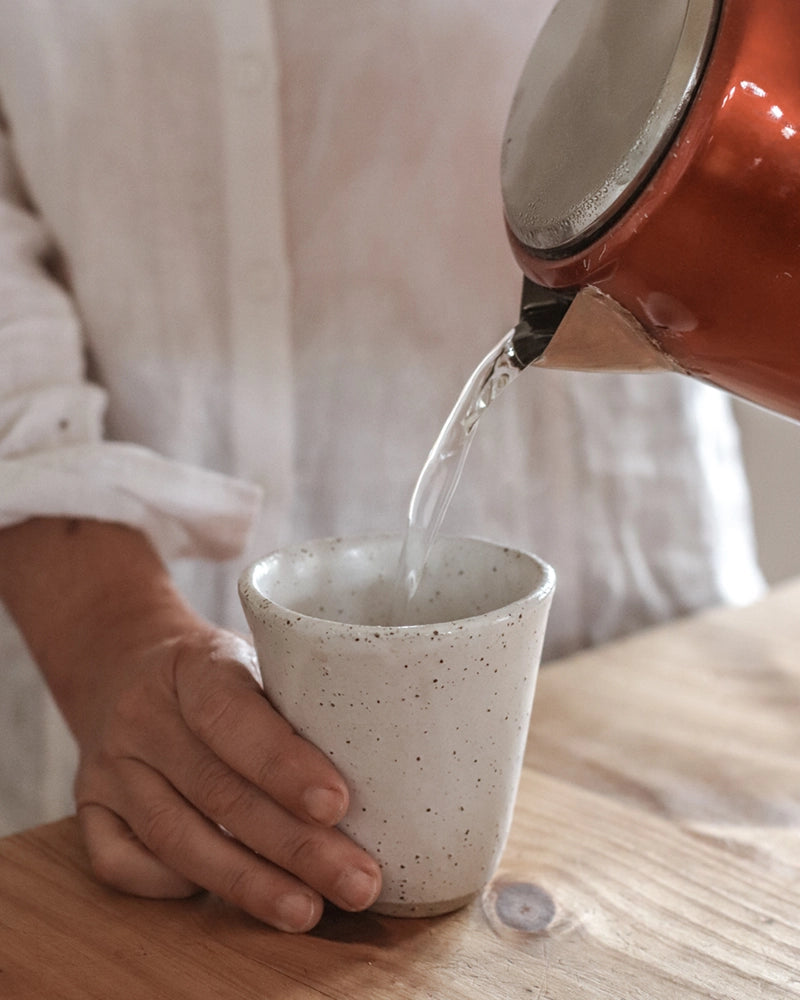 pouring hot water into a latte cup