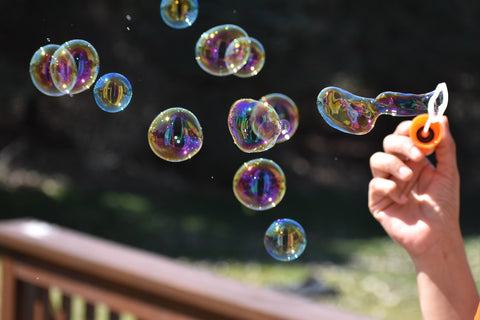 person blowing bubbles in the sun