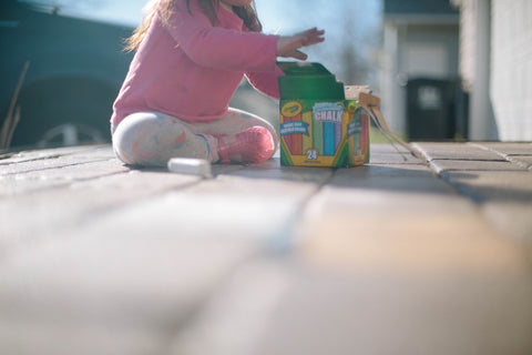 Child playing with sidewalk chalk