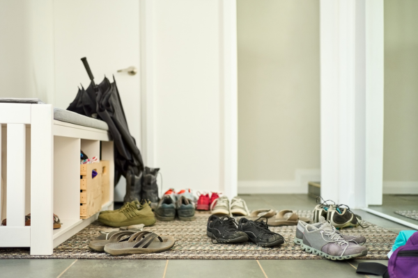 Shoes strewn about an entryway shoe storage space