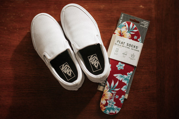 White Vans shoes next to red floral FLAT SOCKS shoe inserts