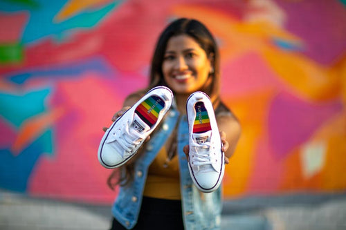 Girl showing her shoes with rainbow FLAT SOCKS added