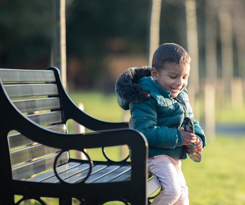 Little boy in park holding dinosaur print FLAT SOCKS