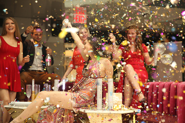Group of friends partying with a multicolor confetti falling