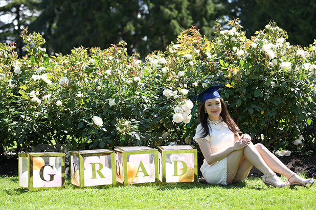 A girl with custom letter 'GRAD' boxes 