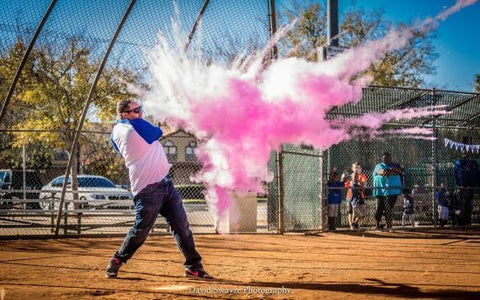 Another guy popped a ball that has pink powder using a baseball bat