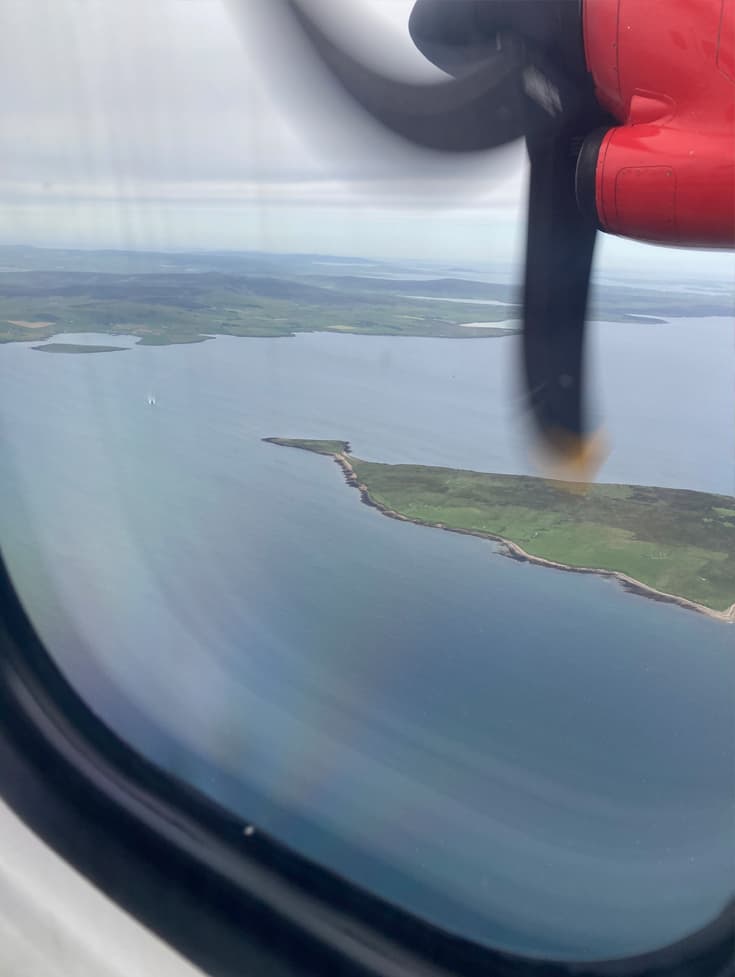 Pullum team view out of plane window to Orkney Islands