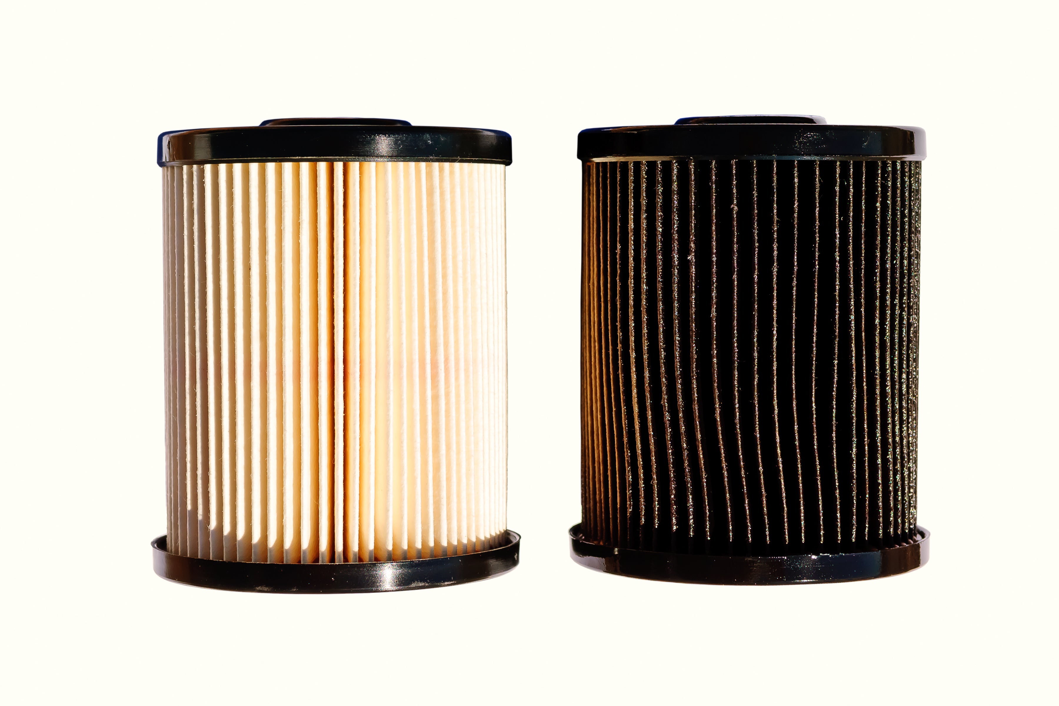 A clean and fresh out of the box diesel fuel filter on the left in contrast with an old and dirty filter on the right. 