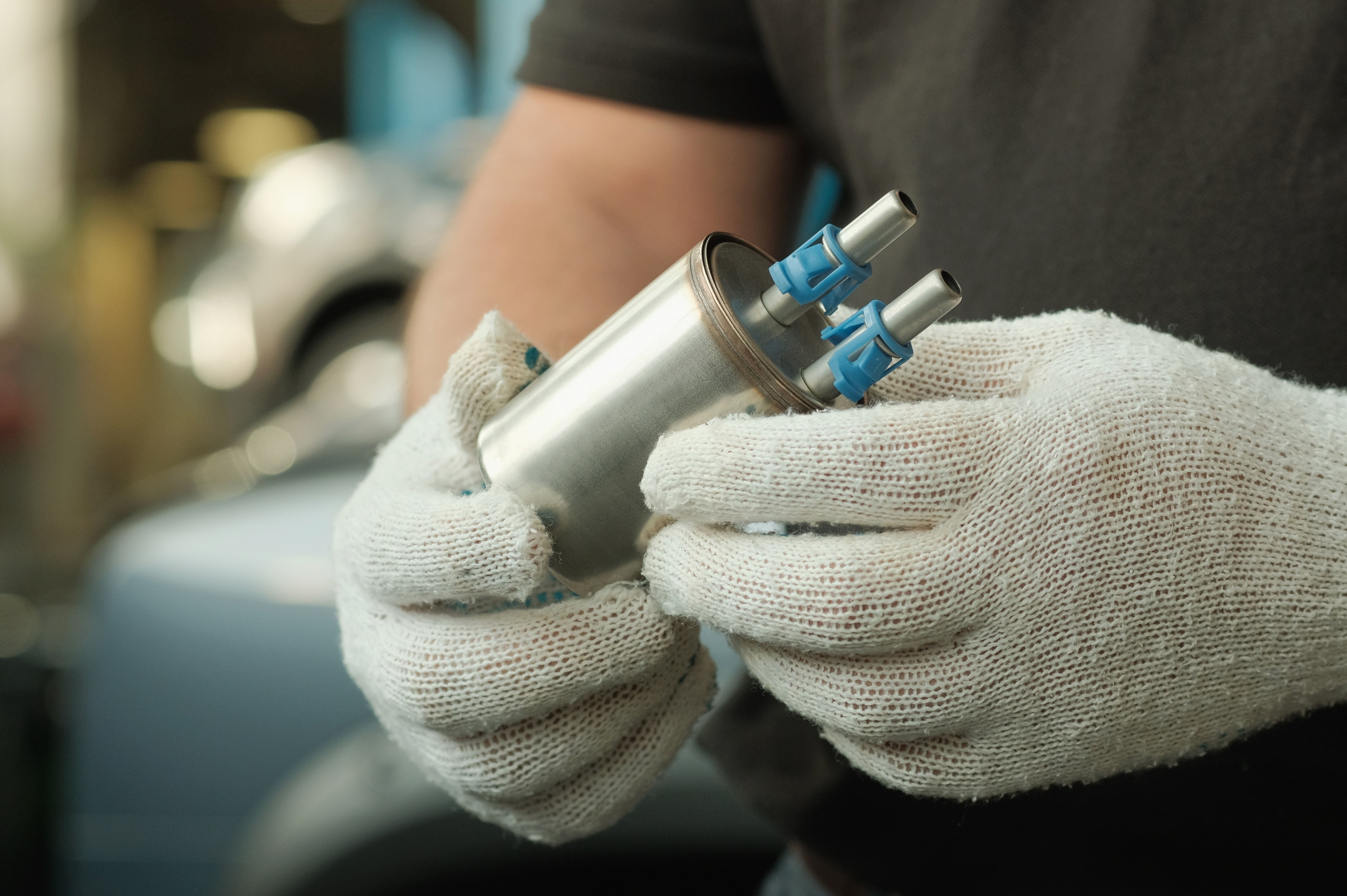 The fuel filter is new in the hands of an auto mechanic. 