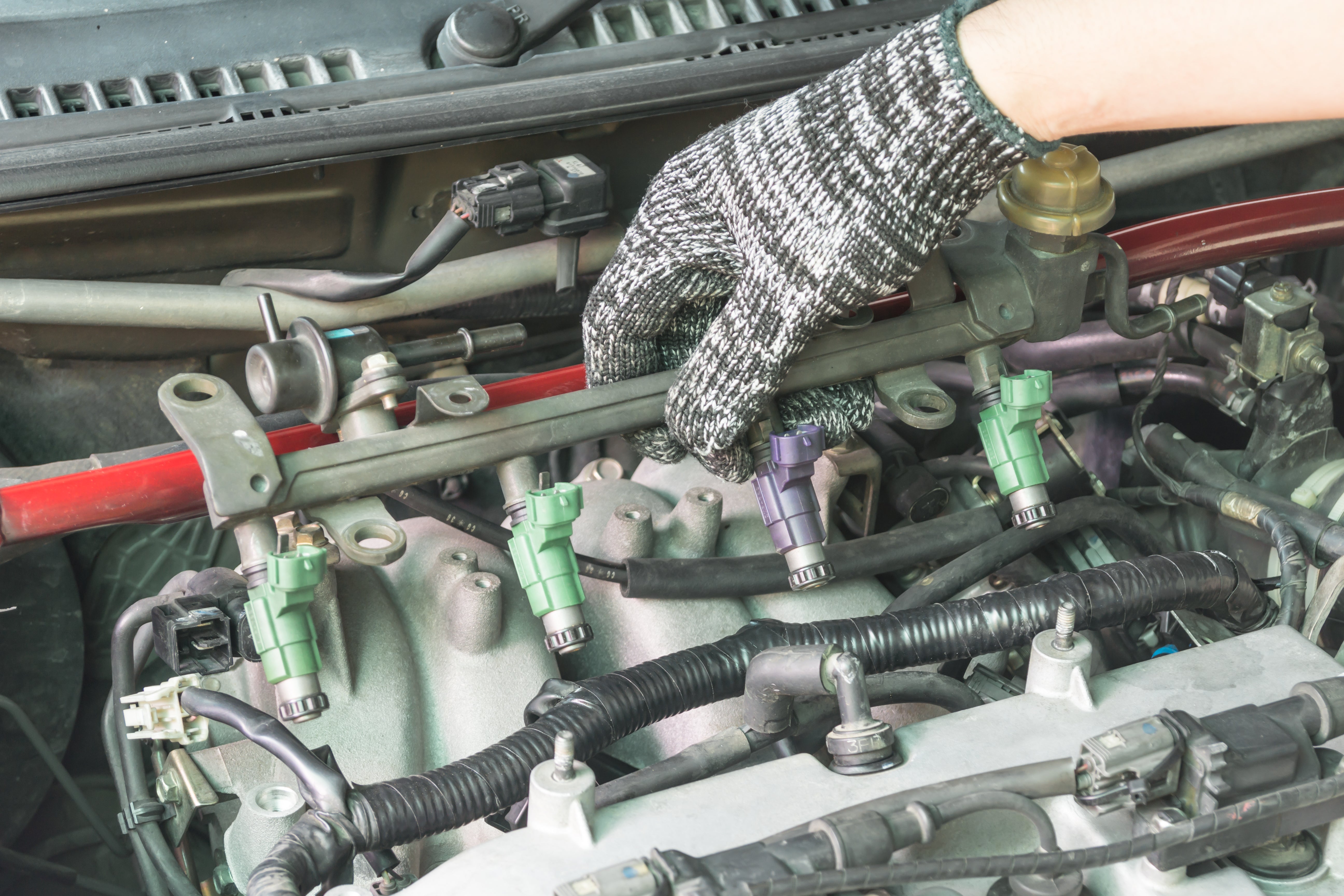 Car mechanic checking the fuel injector system