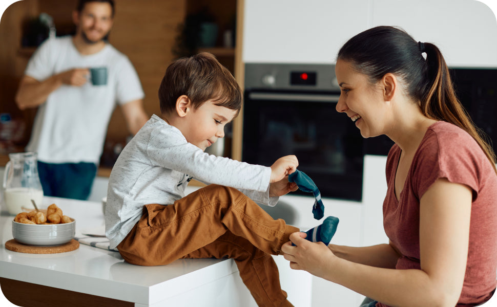 mom putting on sensory friendly socks on her son