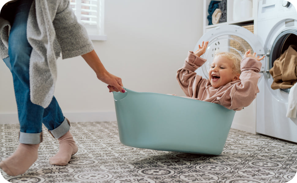 mom and daughter playing in laundry room
