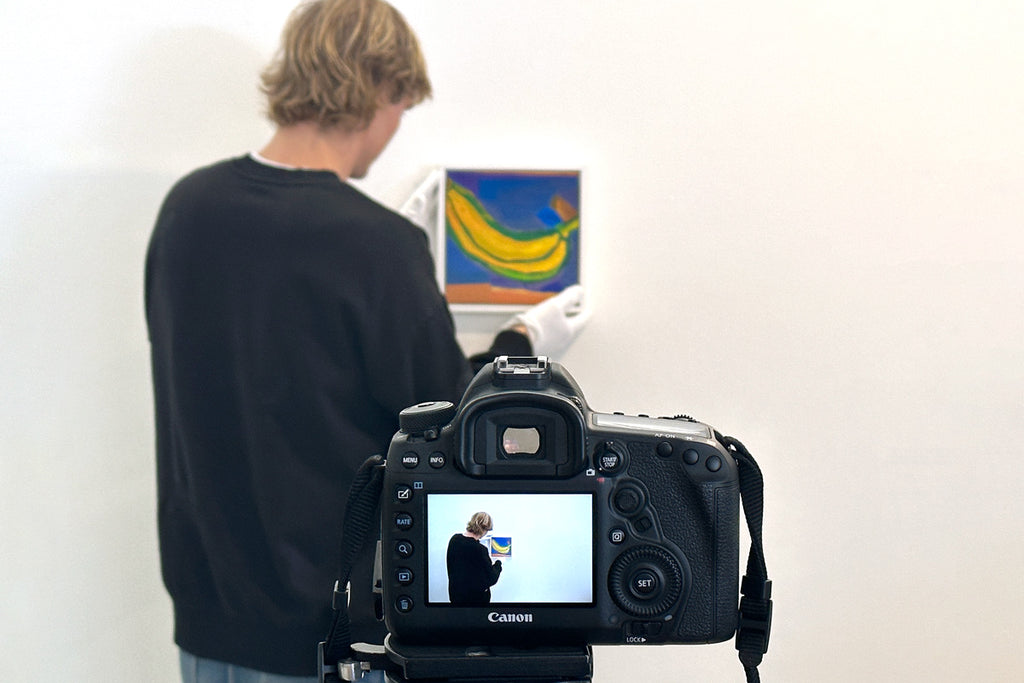 person-photographing-a-banana-painting