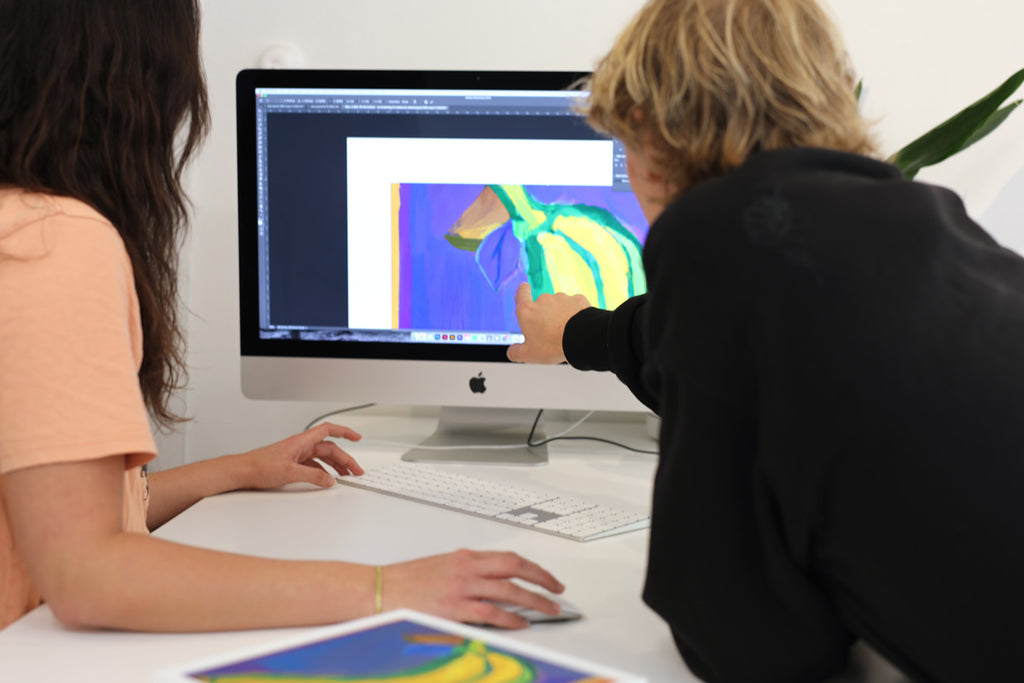 two-people-looking-at-banana-painting-on-computer-screen