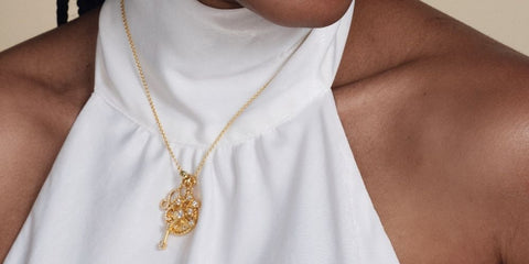Gold necklace with white halter neckline dress