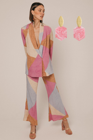 Origineel bedrukt pak voor een lentebruiloft met grote roze oorbellen