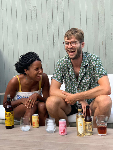 picture of Alex Doman and Denetrias Charlemagne Co-founders AVEC drinks laughing 