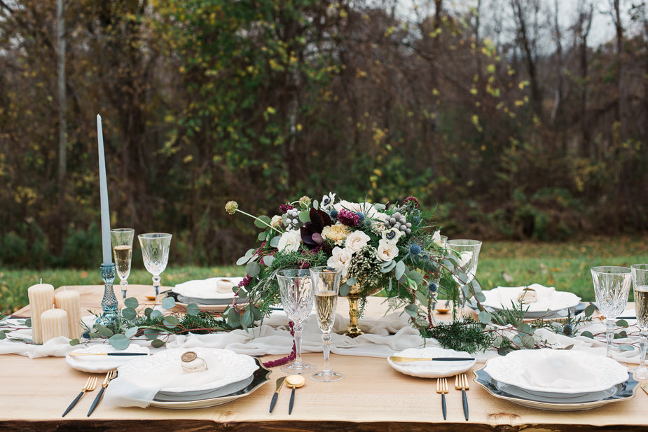 Gedeckter Tisch mit Tellern, Beteck und Blumen