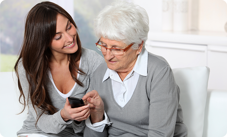 elderly woman and daughter on couch looking at phone