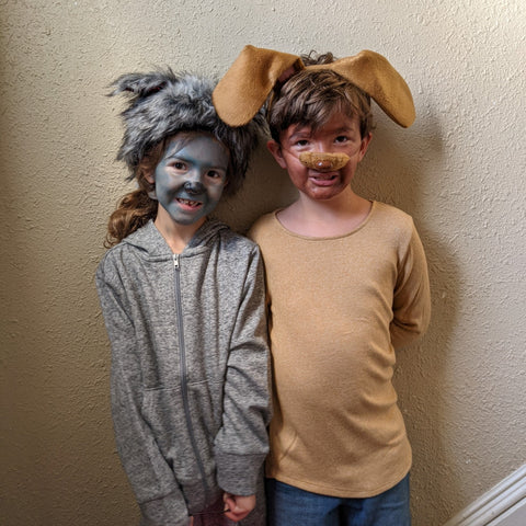 Girl wearing an Irish wolfhound costume next to a boy wearing a brown puppy costume.