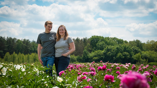 Foto van vaste planten kwekers in een veld met pioenrozen