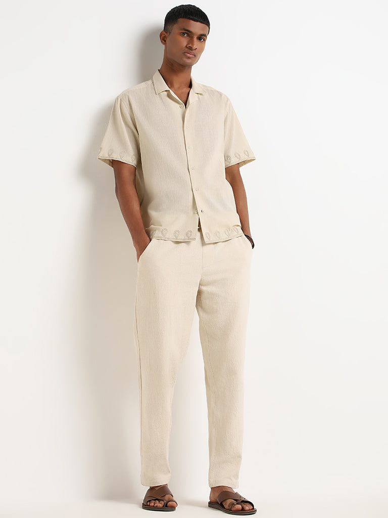 a young man wearing brown pants and a white shirt Stock Photo by Icons8