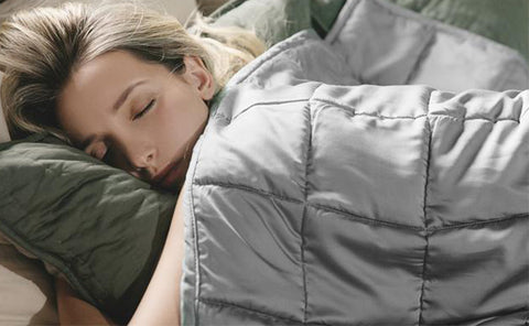 a woman with golden hair is sleeping deeply under a YNM light grey weighted blanket