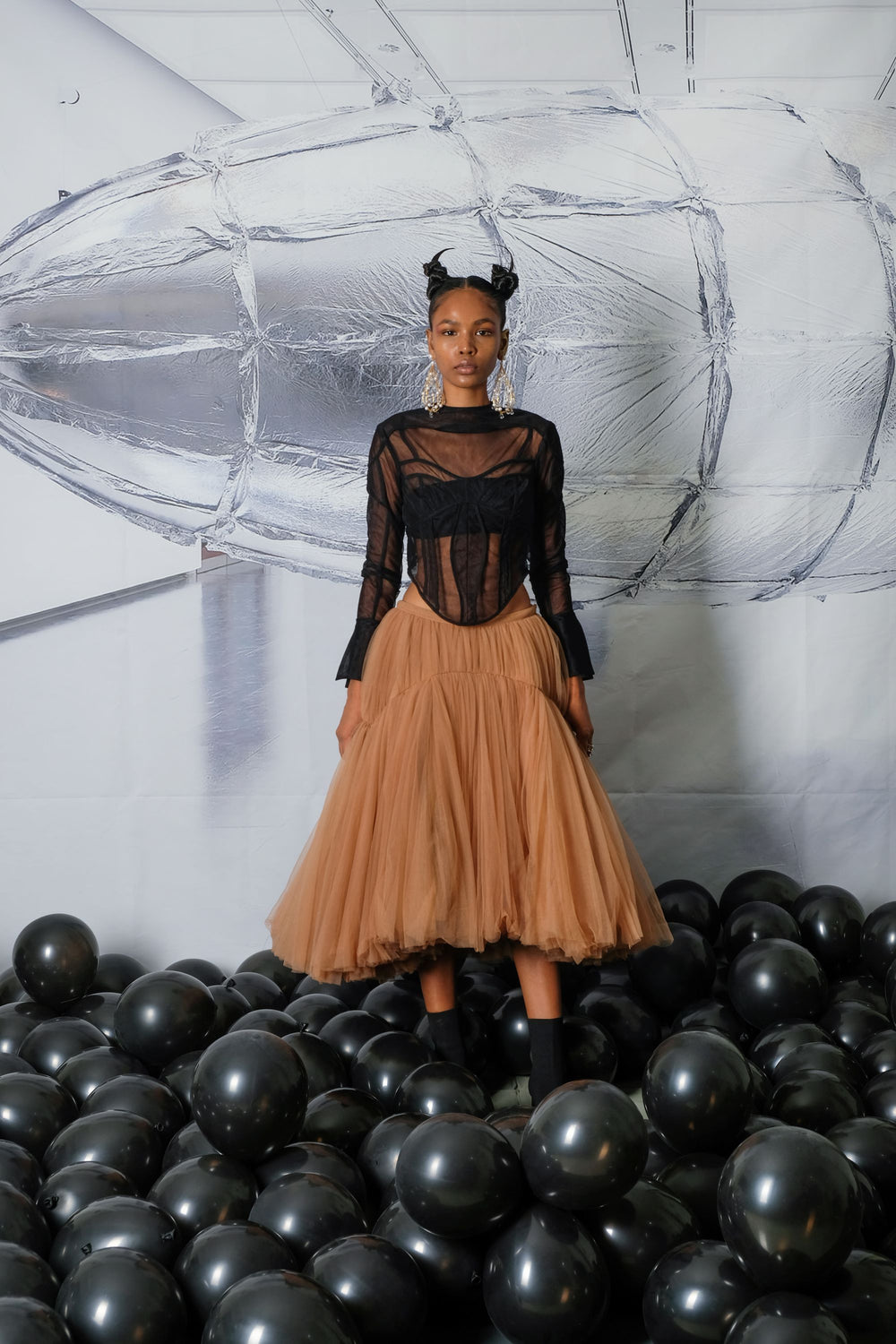 Model is wearing black mesh see-through shirts and long ruffled maxi skirt