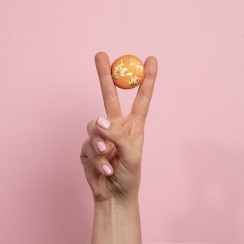 A macaron held between two fingers in the shape of the peace sign at Oh La La! Macarons