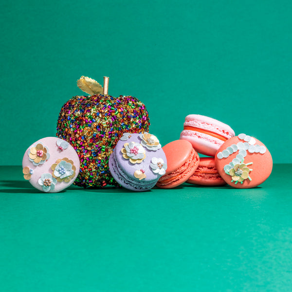 Orange and pink Macarons with edible sequins on them