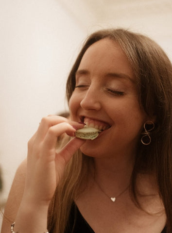 Woman enjoying a macaron at Oh La La! Macarons