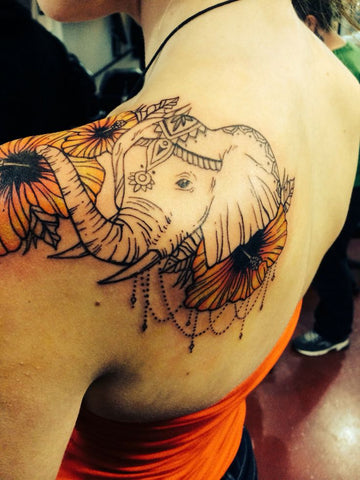 tatouage elephant sur épaule avec des fleurs
