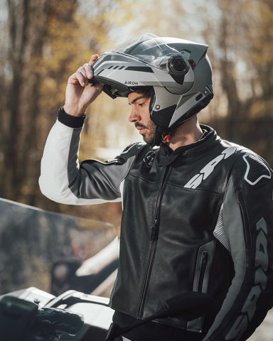 motociclista con casco flip up o abatible de marca airoh color gris