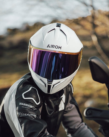 motociclista on road con casco integral de airoh color blanco