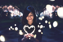 japanese women holding a lit up heart 