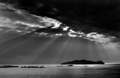 A black and white image of sunrays shining down on the Sleeping Giant.