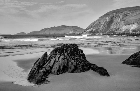 A black and white image of Coumeenole Beach with the Great Blasket Island in the background. 