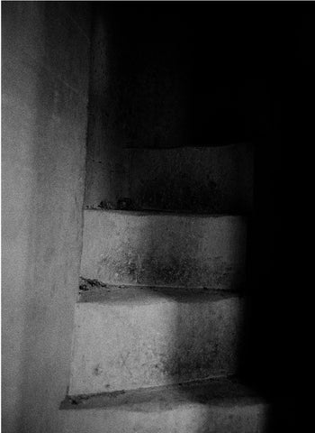 A stone staircase half in shadow and half in light.