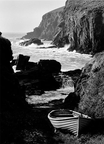 A black and white image of Nohoval Cove with a clinker-built boat in the foreground.