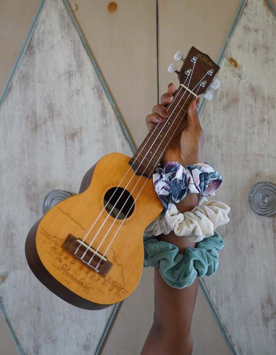 Arm holding ukulele with scrunchies on wrist