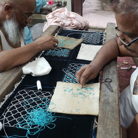 Zardozi artisans at work embroidering purses