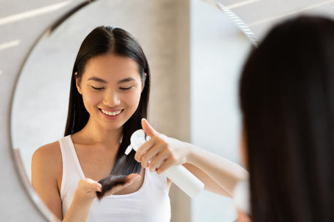 happy linghaired woman using hairspray