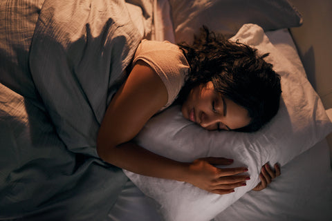 a young woman sleeps soundly in bed